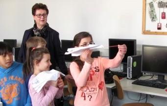 Kinder mit Papierflieger und Lesepatin 