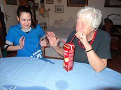 Seniorin und junge Frau beim Versuch Tetrapak-Fontäne